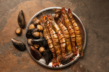 top view of shellfish with cockles and mussels in bowl on textured surface