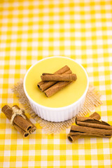 Dessert of curau. Brazilian sweet corn, corn mousse with cinnamon on a wooden background. Typical Brazilian dessert, sweet of June party. Dessert, canjica or Jimbelê.