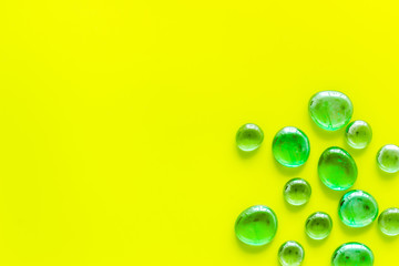 Glass stones for design and home creativity on yellow background top view space for text