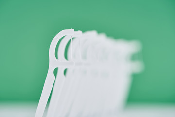 selective focus of white floss sticks isolated on green