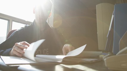 Police officer in precinct solving crimes