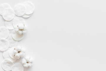 pattern of cosmetic cotton pads and flower on white background top view mockup