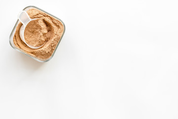 Sports nutrition with scoop and protein on white background top view copyspace