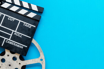 Movie premiere concept with clapperboard, film type on blue background top view space for text