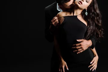 Foto op Plexiglas cropped view of passionate man kissing woman in dress isolated on black © LIGHTFIELD STUDIOS