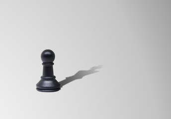 Business Leadership Concept : Pawn chess piece standing on floor with shadow shading on floor in King chess shape.
