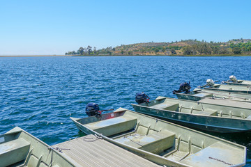Fototapeta na wymiar Small pier with pedal boat, small motor boat. Lake with popular activities including boating, fishing. Miramare Lake, San Diego, California, USA