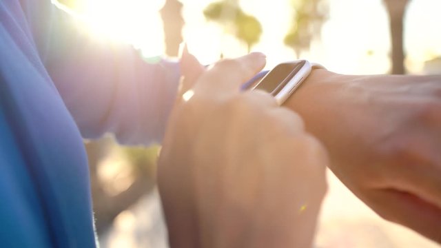 Smartwatch. Woman using smart watch. Closeup of female touching touch screen on watch, entering watch app and starts to run