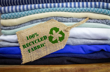 Fototapeta Recycle clothes icon on fabric label with 100% Recycled text. Sustainable fashion and ethical shopping conscious consumerism concept obraz