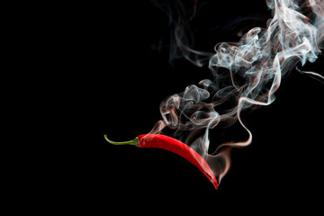 Red chili with smoke on a black background, the concept of spicy