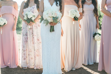 bride and bridesmaids holding wedding bouquets, pastel bridesmaids dresses, detail shot, copy space