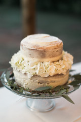 Small white wedding cake with white flowers, detail shot, copy space