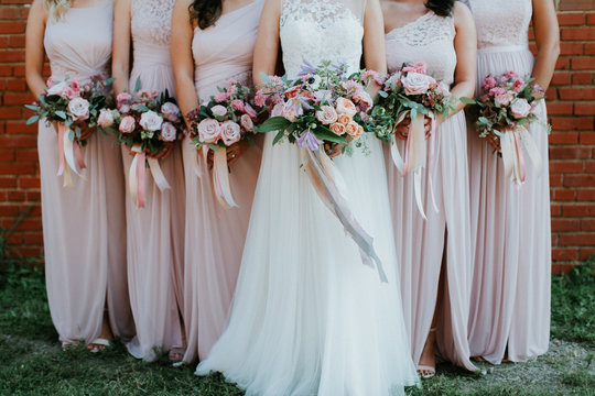 bride and bridesmaids holding wedding bouquets, pink bridesmaids dresses, detail shot, copy space - Powered by Adobe
