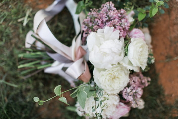 Modern wedding bouquet with white peonies and pink and purple flowers, silk ribbon greenery, close up