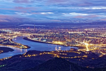 Aerial panorama over Taipei, the capital City of Taiwan, on a blue gloomy evening with view of the...