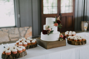 Modern White Wedding Cake with pink and red roses, stacked cake with vanilla icing, wedding reception 