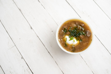 Chunky Italian wedding soup on a light wood background table
