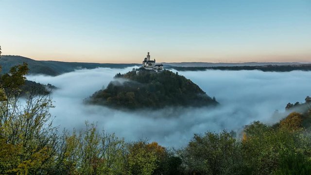 Timelapse of clouds flowing around a castle on a hilltop at the river rhine in germany