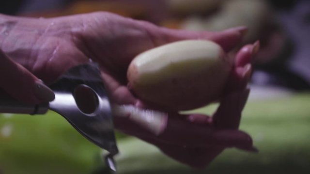 Women's hands wash, peel and cut vegetables into vegetable stew.