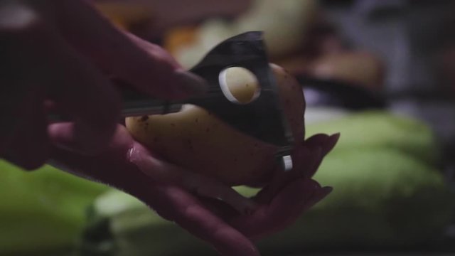 Women's hands wash, peel and cut vegetables into vegetable stew.