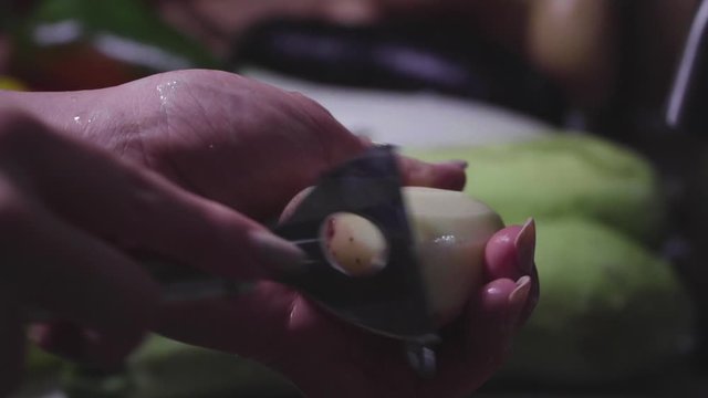 Women's hands wash, peel and cut vegetables into vegetable stew.
