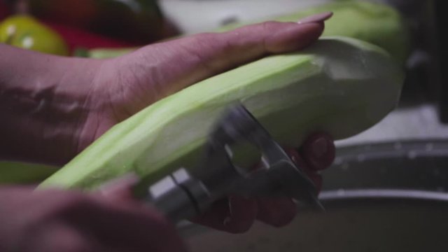 Women's hands wash, peel and cut vegetables into vegetable stew.
