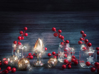 Shining Christmas decorations and a metal butt plug (sex toy) are on a black wooden background. Image for a sex shop for Christmas and New Year.
