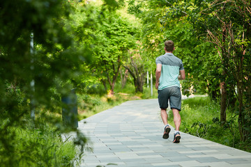 Man is jogging in the park on green background - 282764750