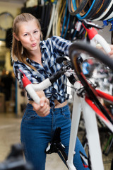 Fototapeta na wymiar Smiling girl is standing with bicycle