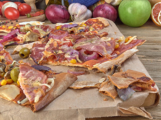 Pizza on thin dough.With slices of salami and ham ,olives and tomatoes.