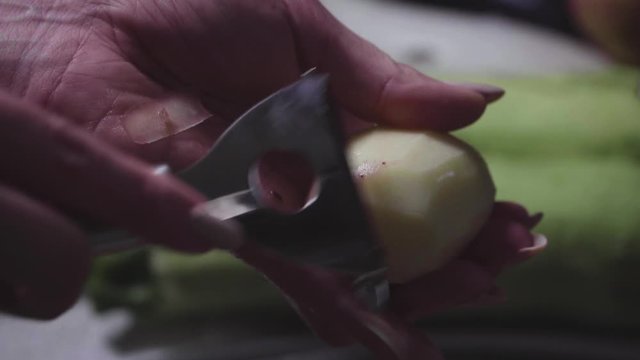 Women's hands wash, peel and cut vegetables into vegetable stew.