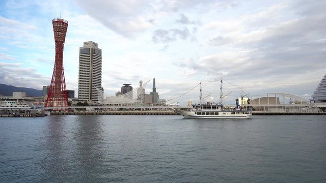 Wide shot of Kobe, Japan overlooking the port with a boat passing by