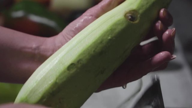 Women's hands wash, peel and cut vegetables into vegetable stew.