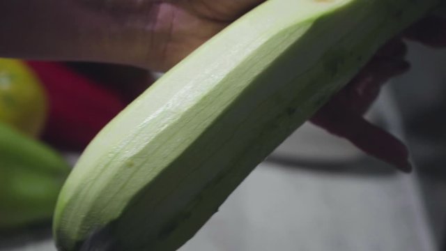 Women's hands wash, peel and cut vegetables into vegetable stew.