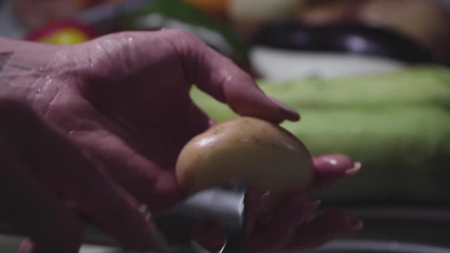 Women's hands wash, peel and cut vegetables into vegetable stew.