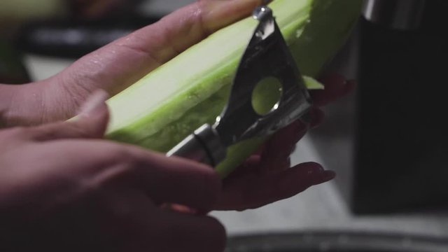 Women's hands wash, peel and cut vegetables into vegetable stew.