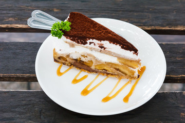 Banoffee cake on wooden table.