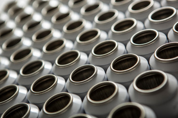 Numerous white aluminum aerosol cans against a white background. the boxes are in the raw form and in a row in a row.