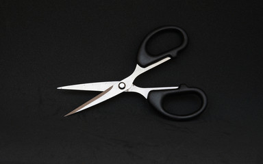  Black scissor in black background    