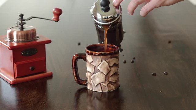 Pouring coffee from French press coffee maker
