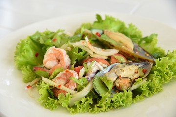 spicy salad with pork and shellfish and squid on the table in a restaurant