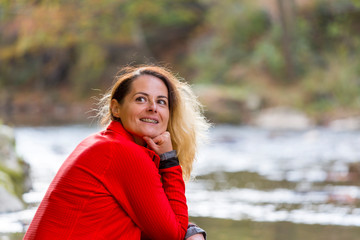 Naklejka premium Beautiful young woman enjoying autumn by the side of a wild lake