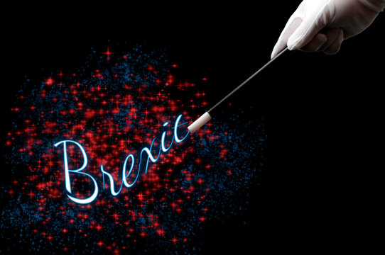 Great Britain leaving the EU is a magic trick concept theme with magician hand wearing white gloves and witting with a wand the word Brexit surrounded by pixie dust