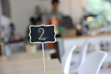 Close up two number or  Queue waiting for number two and blur coffee shop.