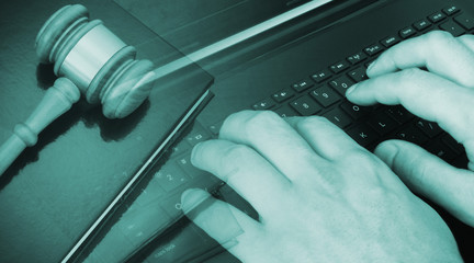 Cyber law or online legal help concept, judge gavel with legal books and computer keyboard with...