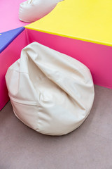 White bean bag in colorful playground corner for relax.