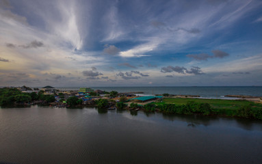 The natural background of the sky is blurred from the twilight light in the evening. There are a variety of colors, trees (mangroves, rivers, waterfront communities), complementary living