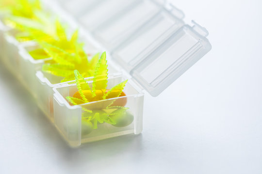 Pillen, Tabletten, Kapseln mit Cannabis Marihuana Hanf und CBD gegen Schmerzen zur Therapie als Medizin Arzneimittel in Pillenbox