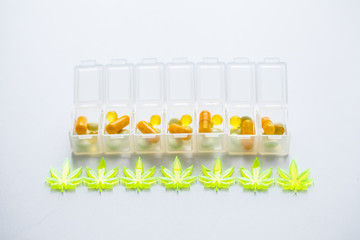 Pillen, Tabletten, Kapseln mit Cannabis Marihuana Hanf und CBD gegen Schmerzen zur Therapie als Medizin Arzneimittel in Pillenbox