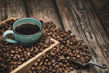 cup of coffee and beans on brown wooden table with text space